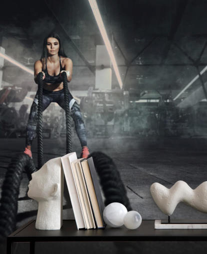 Powerful muscular woman fitness trainer do battle workout with ropes mural