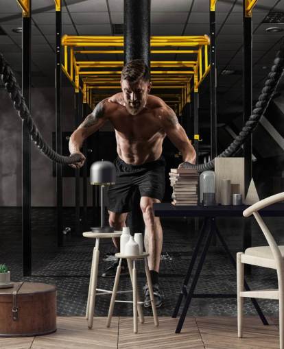 dunkles Fitnessstudio mit Mann mit schwerer Seile-Tapete