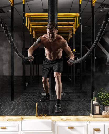 dark gym with man with heavy ropes wallpaper