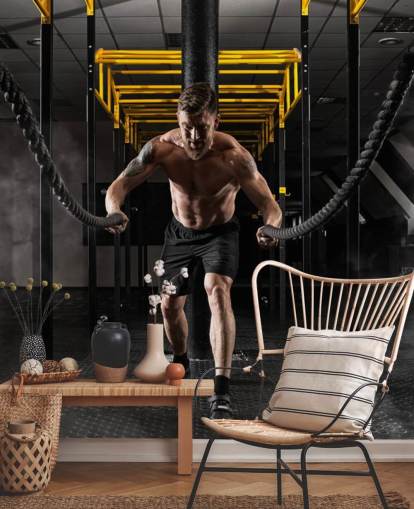 dunkles Fitnessstudio mit Mann mit schwerer Seile-Tapete