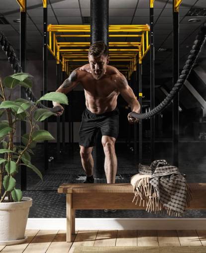 fondo de pantalla oscuro de gimnasio con hombre con cuerdas pesadas