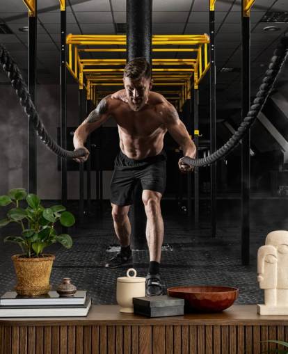 fondo de pantalla oscuro de gimnasio con hombre con cuerdas pesadas