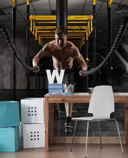 dunkles Fitnessstudio mit Mann mit schwerer Seile-Tapete
