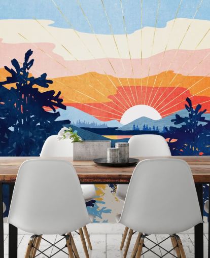 Hvid sol går ned bag en sø med blå bjerge og træer 