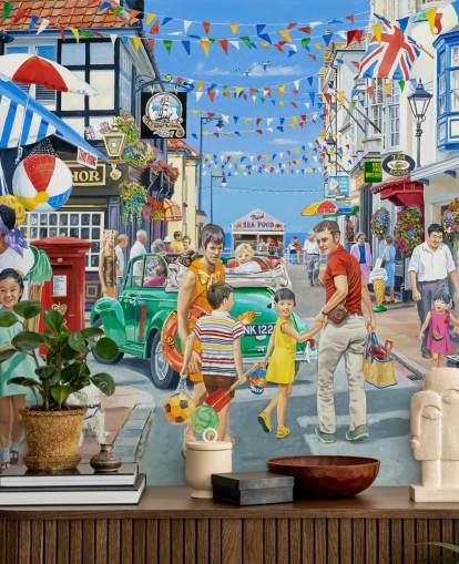 Rua colorida à beira-mar com faixas, lojas e bandeirolas