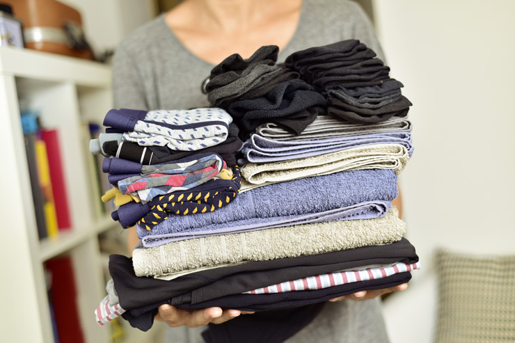 woman holding folded clothes