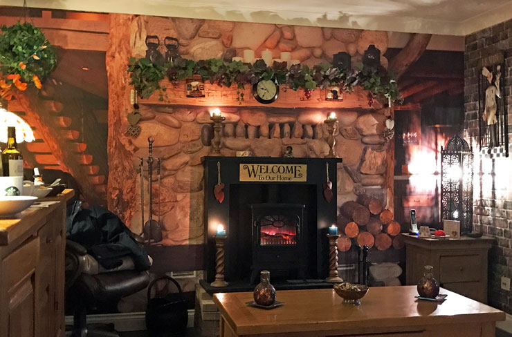 cosy lounge with pretend chimney breast in a log cabin wallpaper