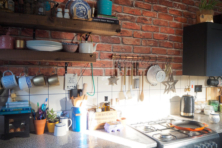 brick effect wallpaper above trendy kitchen counter top