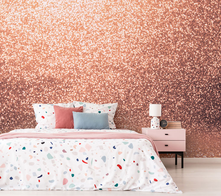 rose gold glitter effect wallpaper with terrazzo patterned bed