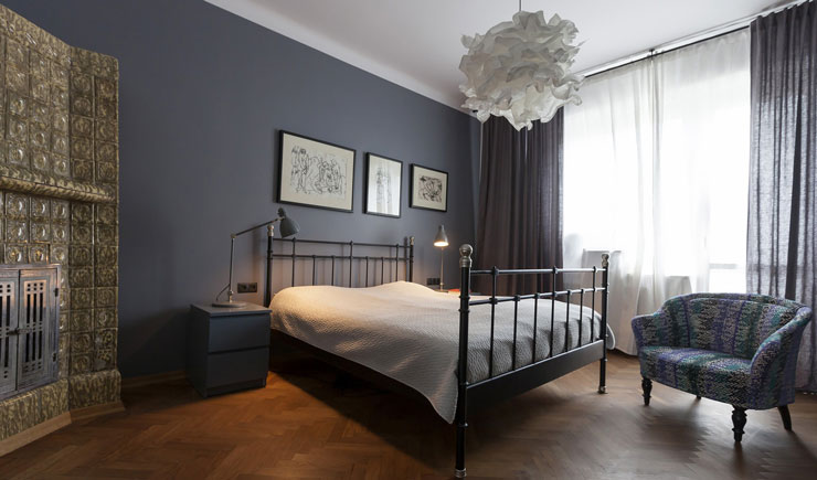 blue bedroom with metal bed and soft furnishings