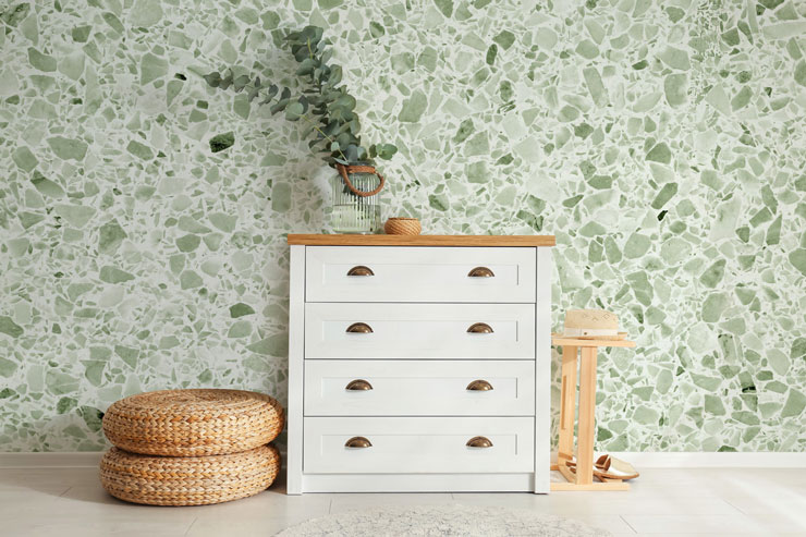 white and pale sage green terrazzo wall mural in white and wicker hallway