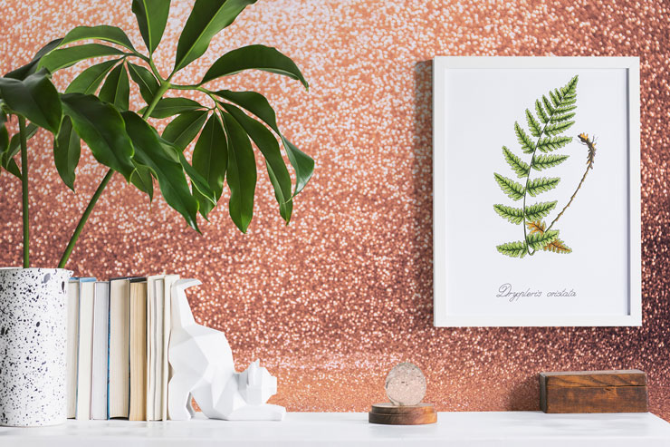 pretend pink glitter wallpaper next to book shelf and tropical plant
