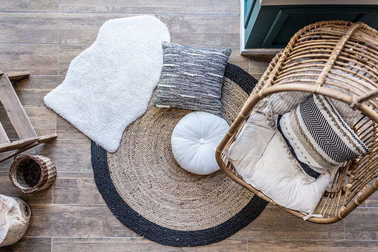 boho wicker hanging chair and an assortment of rugs and cushions