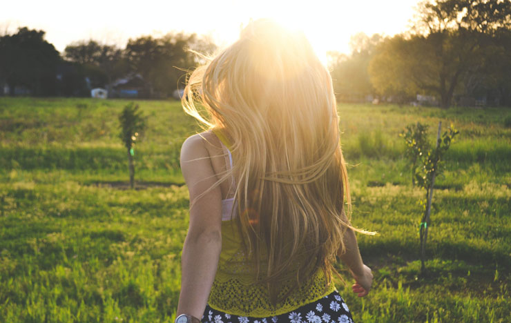 blonde lady running in a sunset lit meadow