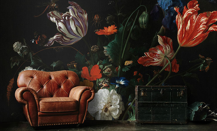 antique painted flowers wall mural with brown leather chair and black chest