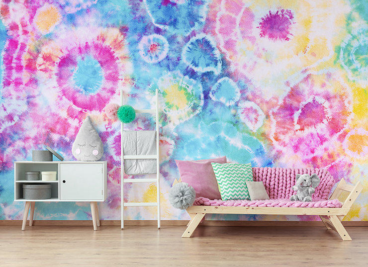 pink, blue, yellow and white tie dye wallpaper in girl's bedroom with pink sofa