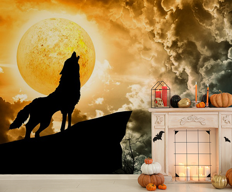 black wolf silhouette howling against orange moon mural in halloween decorated lounge with fireplace