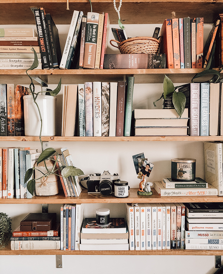 wooden book shelves holding books, photographs and trinkets