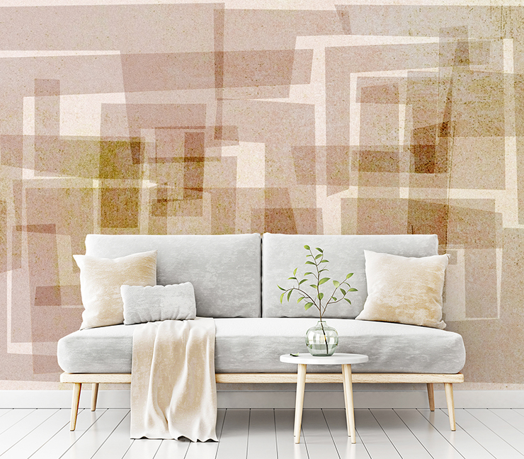 block printed brown shapes on beige background wallpaper with grey sofa with cream cushions and blanket