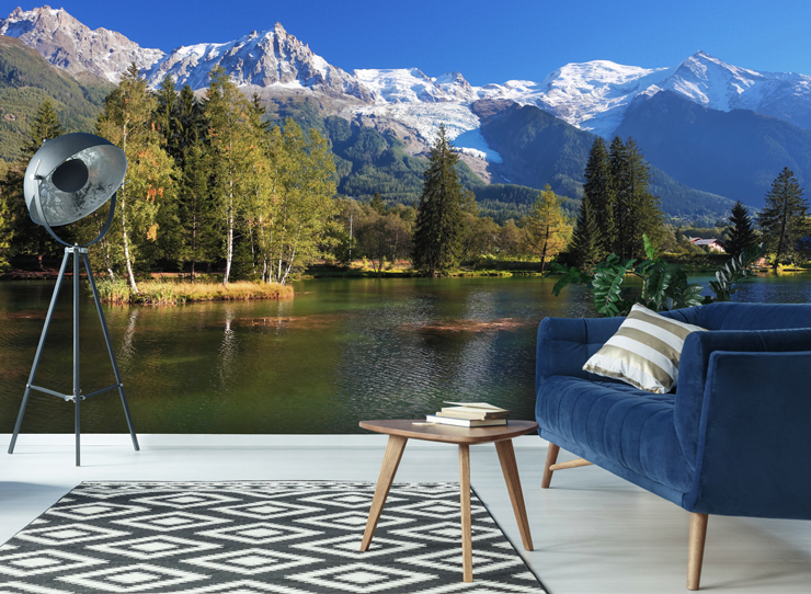 beautiful lake and green forest with snowy mountains wallpaper with blue sofa and metal lamp
