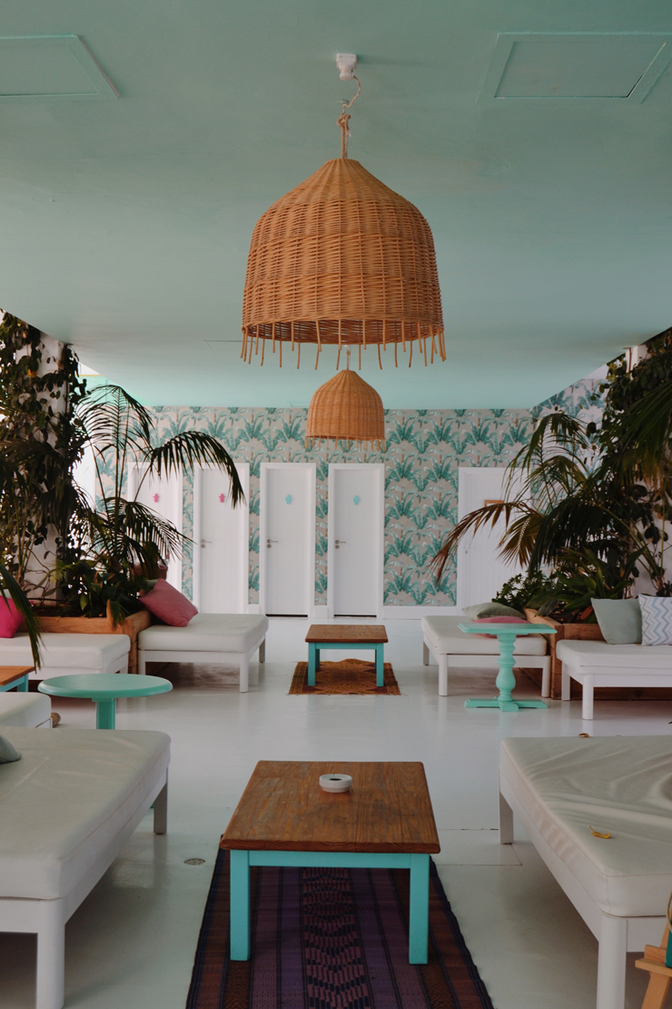 beach house room with wicker lampshades, duck egg blue ceiling and tropical wallpaper