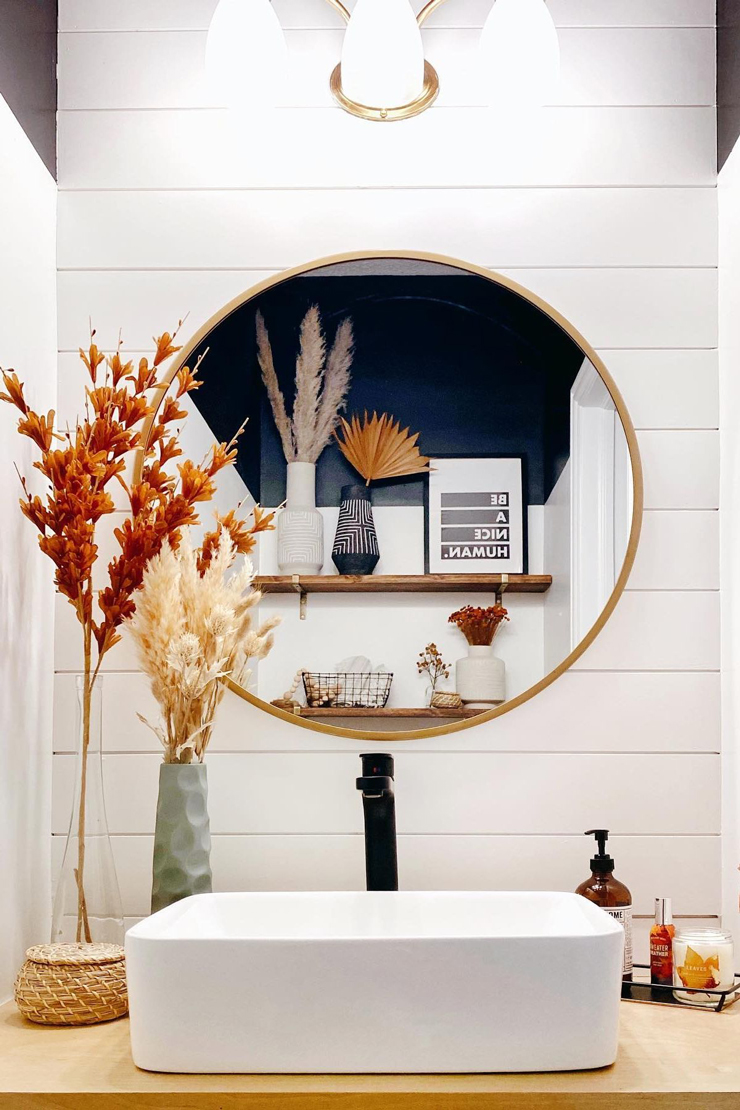 orange fried flowers on white bathroom sink with wooden accessories