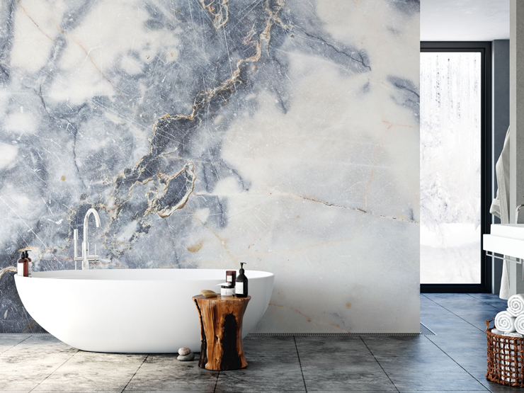 blue, grey and white marble wall mural in large bathroom with free-standing bathtub