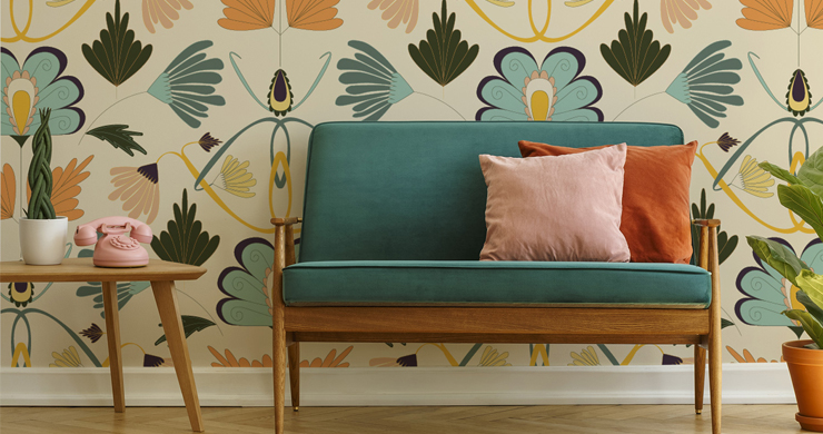 teal green sofa with pink and orange cushions with art nouveau feature wall