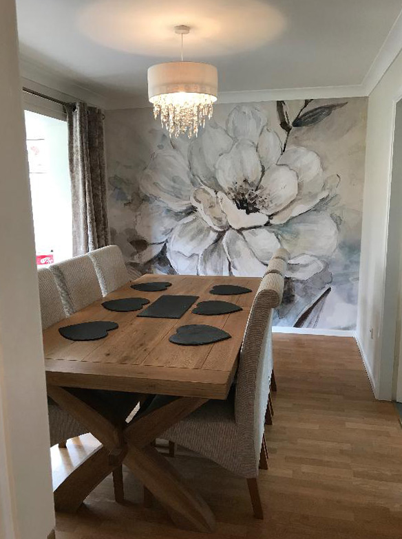 grey and off-white painted floral wallpaper in dining room with wood dining table