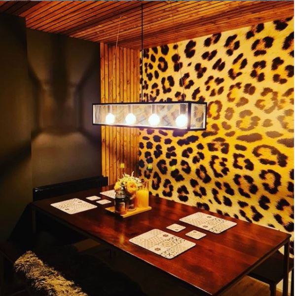photo of jaguar print wallpaper in dark wooden dining area