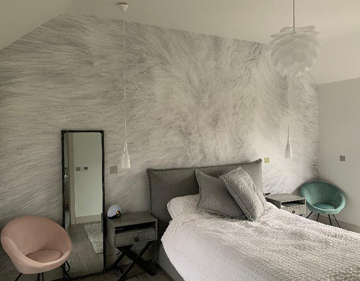 off-white/grey rabbit fur wallpaper in bedroom with pastel pink and green accessories