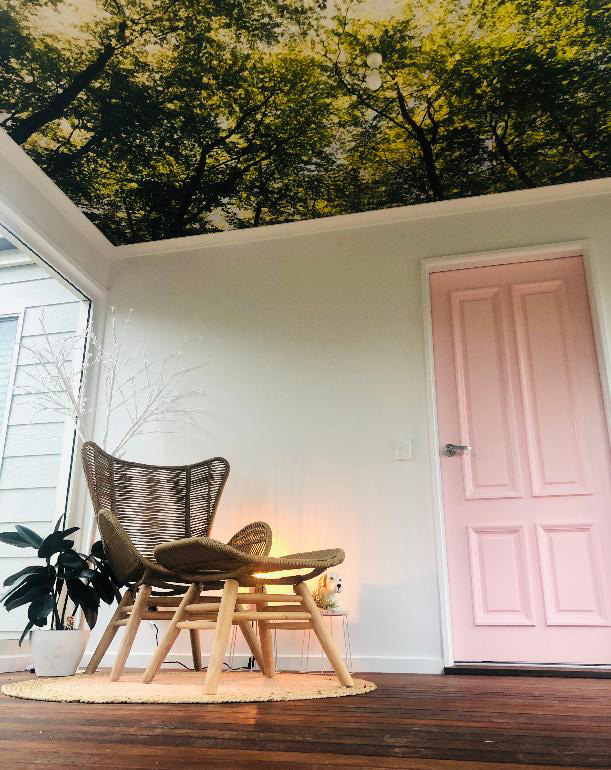 pink and white room with tree wallpapered ceiling