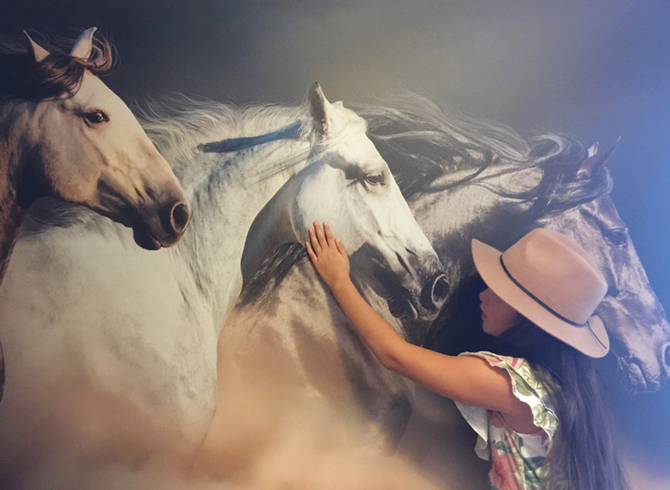 3d effect horse wallpaper with young girl stroking one of the horses