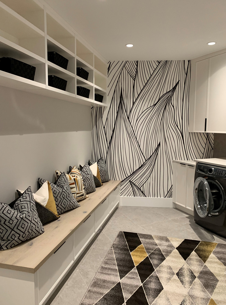 black and gold themed laundry room with black and white leaf illustration wallpaper