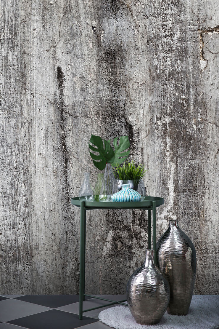 grey and black concrete effect wallpaper with green and silver room accessories