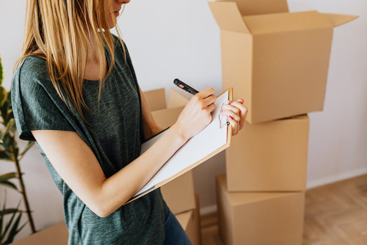 blond woman writing a list whilst moving house