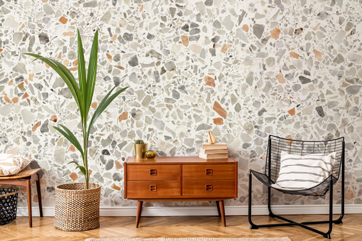 rusty brown, grey and off-white terrazzo wallpaper in lounge with wooden furniture and black metal chair