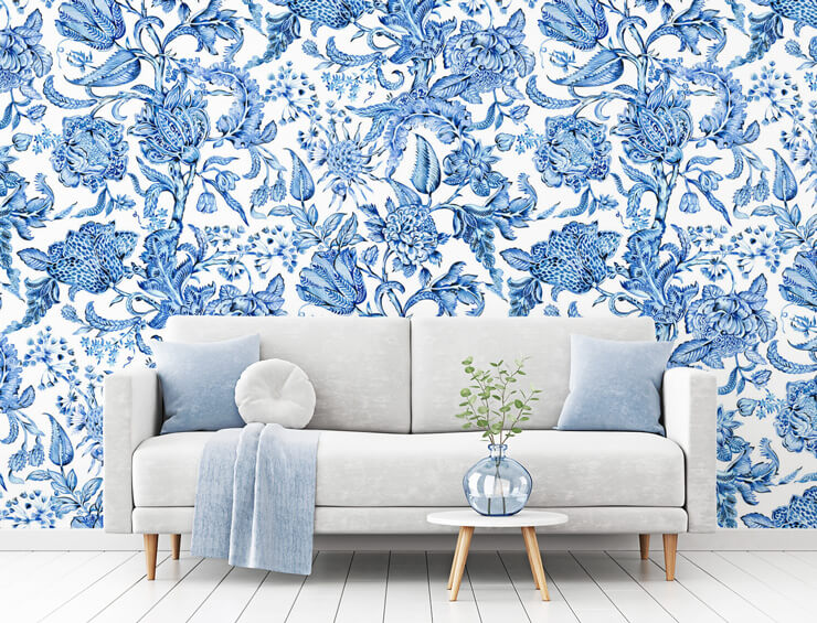 blue and white floral wallpaper in living room with off white sofa with blue cushions