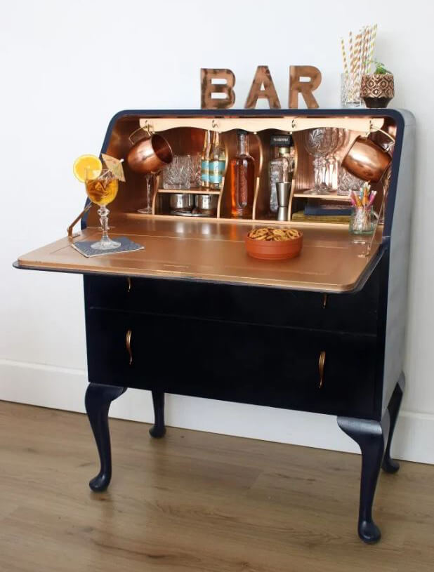 upcycled bureau in black and gold with drinks bottles inside
