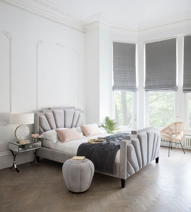 grey, white and pastel pink scalloped bed in white bedroom