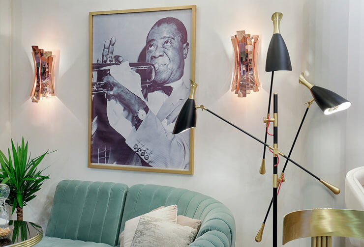 room with bleu sofa, rose gold wall scones and gold and black lamp with louis armstrong print