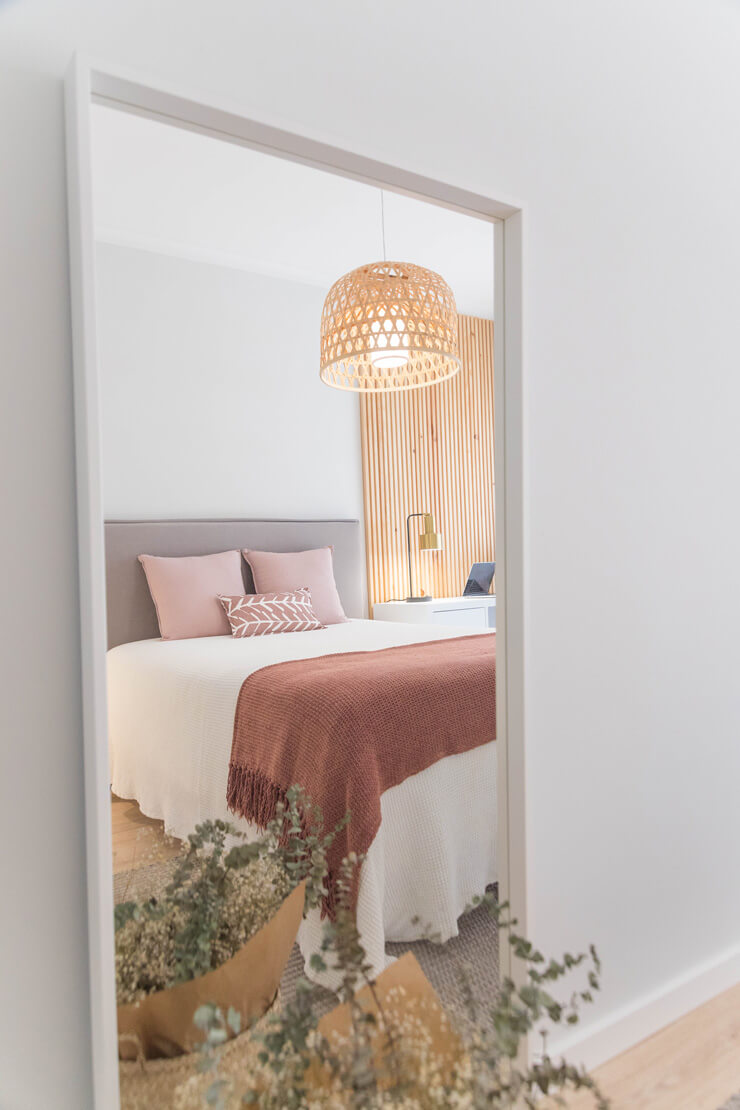 door view of pink and white bedroom with wicker lampshade