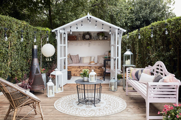 white summer house with wooden decking and beautiful accessories