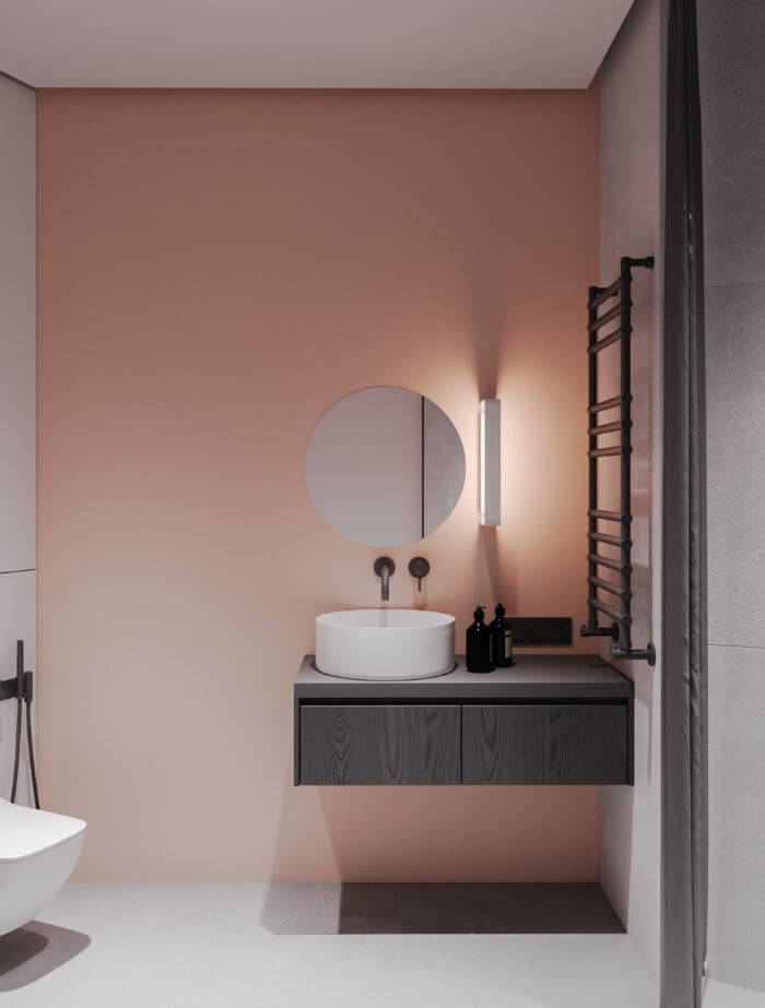 pink minimalist bathroom design with round mirror and grey accessories