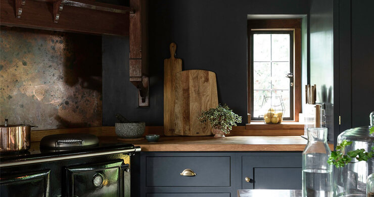 old fashioned kitchen with dark blue units, walls and natural wooden accessories