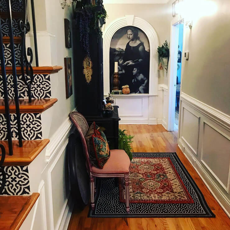 black and white portrait of woman installed in white alcove in vintage hallway