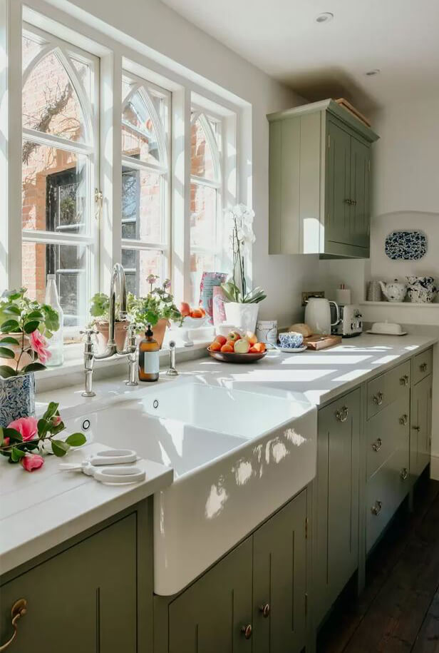 green cabinets and belfast sink in kitchen