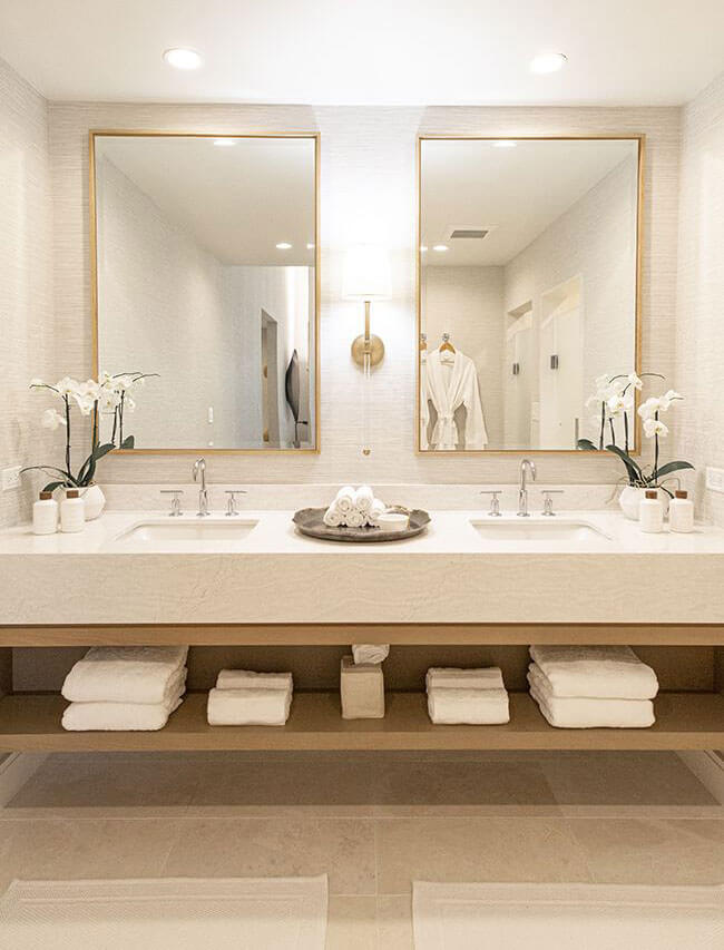 white and gold bathroom with towels and matching mirrors