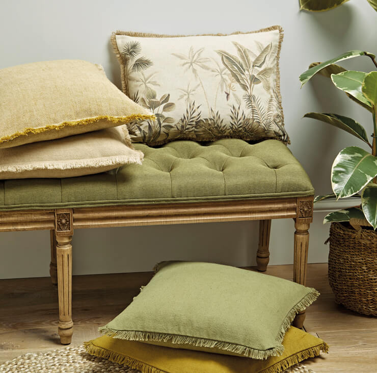 green jungle patterned cushion covers on a golden stool