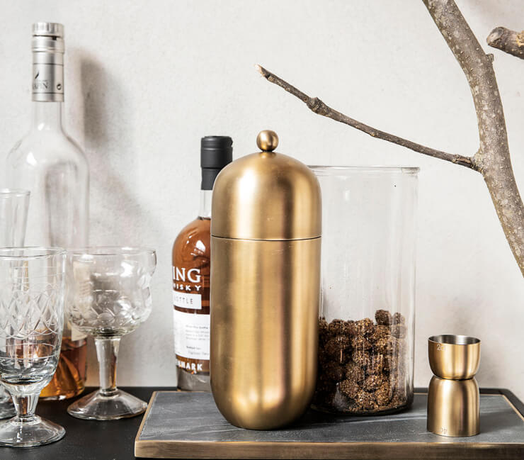 brassy gold cocktail shaker on bar table